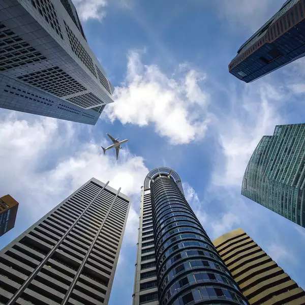 view of skyscrapers, looking straight up at a blue sky