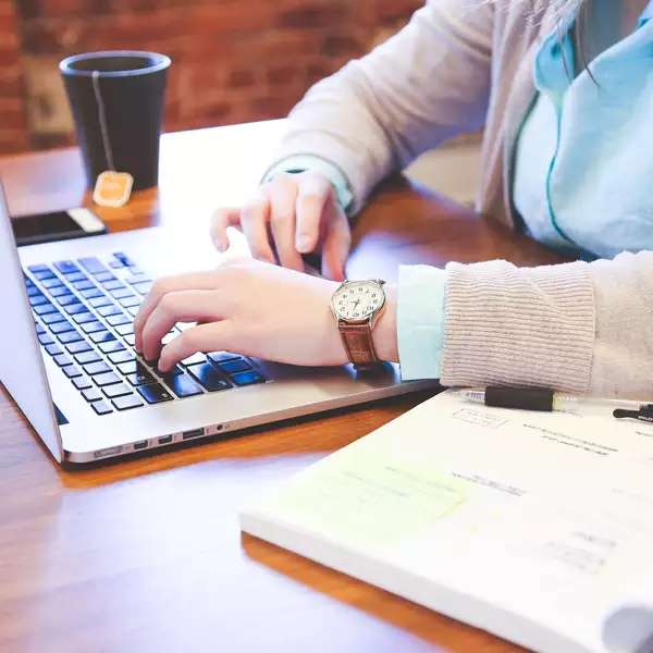 close up of a student's hands on an open laptop