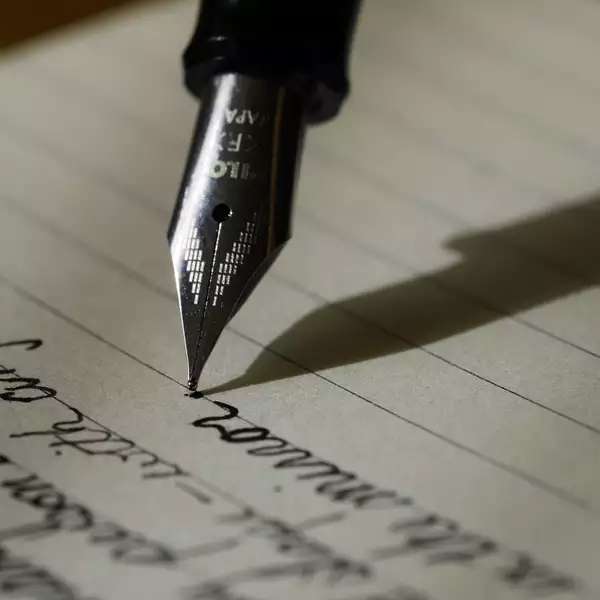 a pen with a nib writing on lined paper