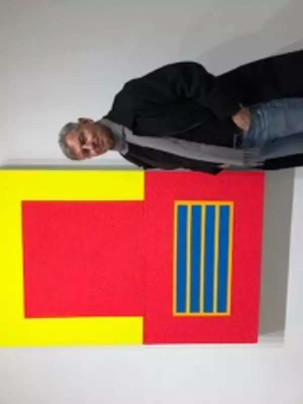 Professor Alfred Mac Adam standing in front of a red and yellow painting